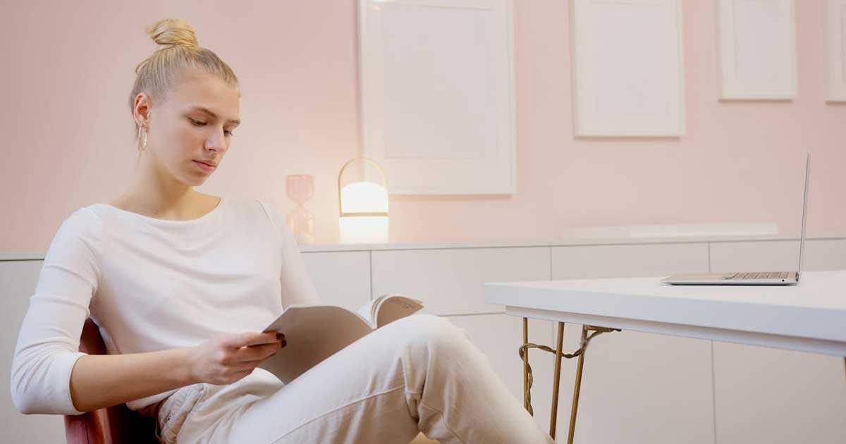 Person reading in a calm, minimal space reflecting thoughtful curation and design