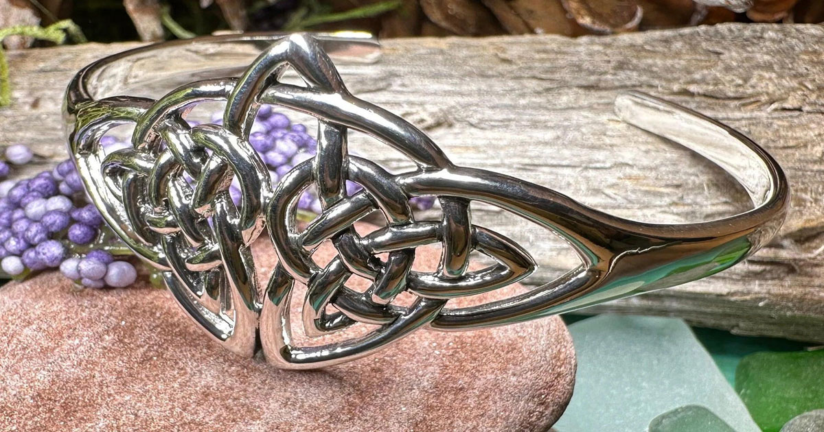 Celtic knot bracelet on natural stone with wood and greenery background