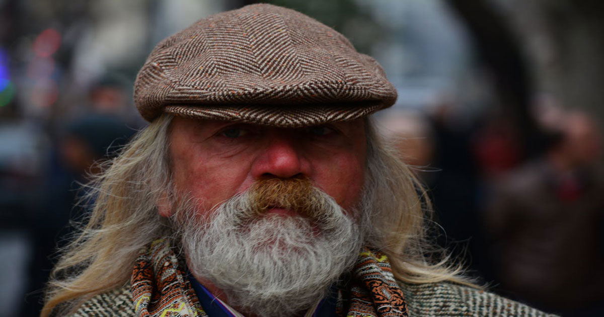 Irish man wearing traditional tweed cap and scarf with classic Irish style